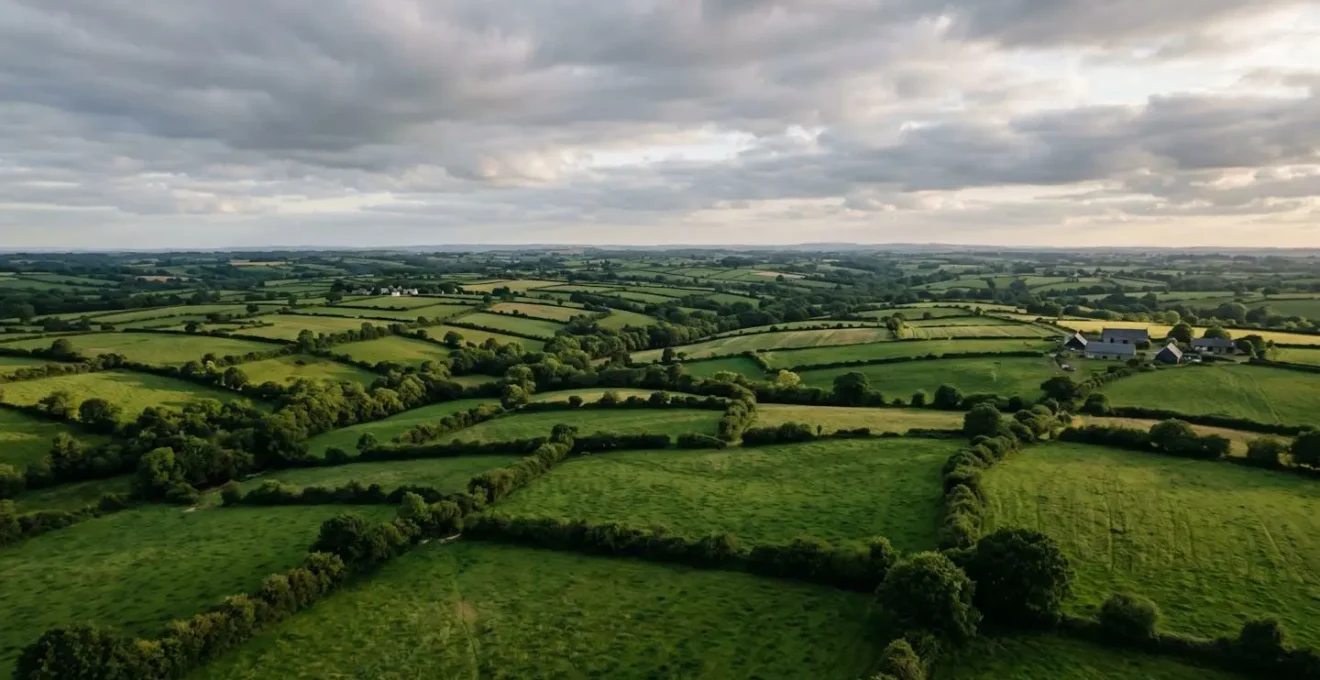 Vue panoramique de paysages agricoles bretons avec bocages et prairies verdoyantes sous ciel nuageux